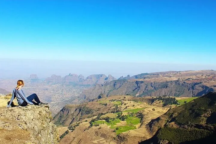 Trekker overlooking the Simien Mountains escarpment from a cliff-edge viewpoint
